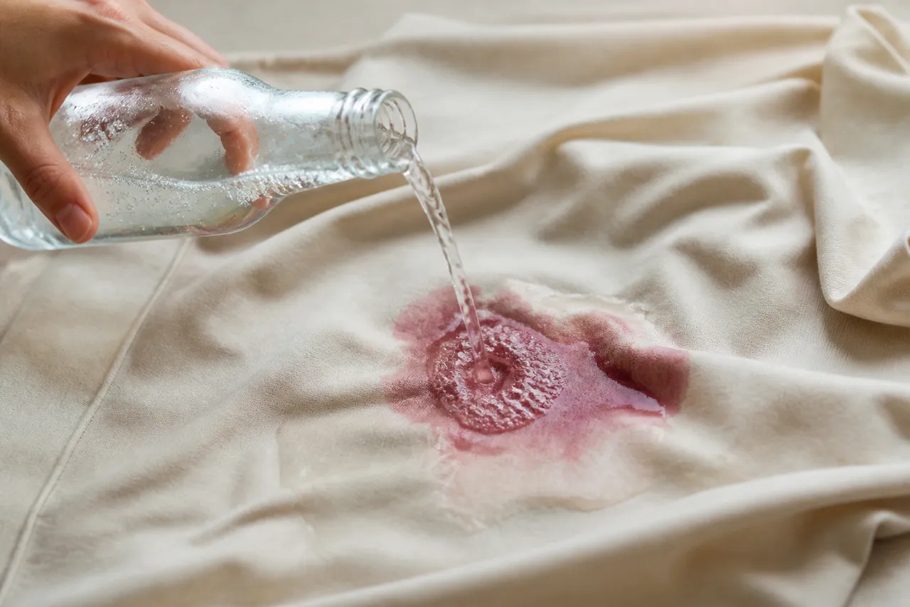 Eau gazeuse sur une tache de vin rouge