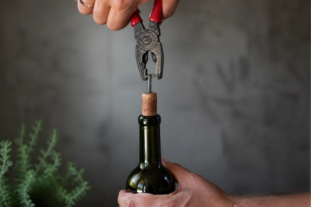Retrait d'un bouchon de vin avec une vis et une pince